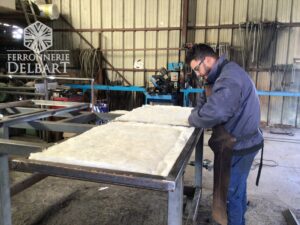 création d'une porte acier sur mesure double peau isolée positionnée sur une table acier dans notre atelier de serrurerie Ferronnerie Delbart en Haute Provence (04).