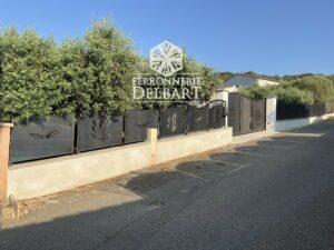 clôture portail en acier à motifs découpe laser fixé dans un muret entouré d'oliviers. Ferronnerie Delbart Les Mées en Haute-Provence